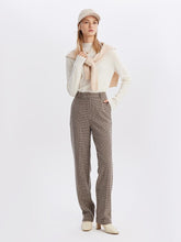 A lady wears wool plaid pants.